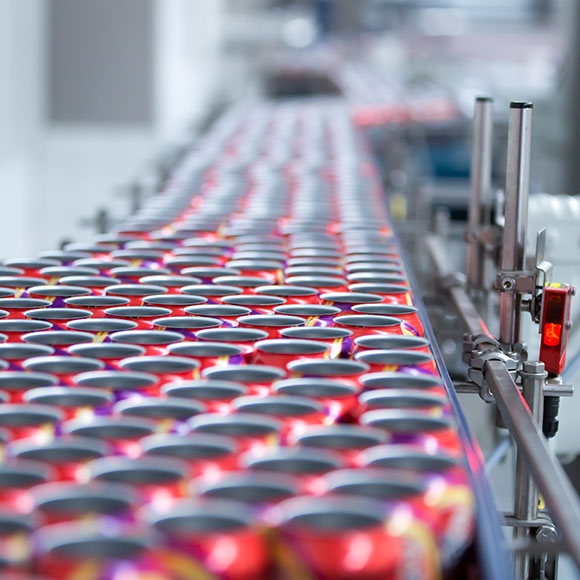 Lots of soda cans on a production line.